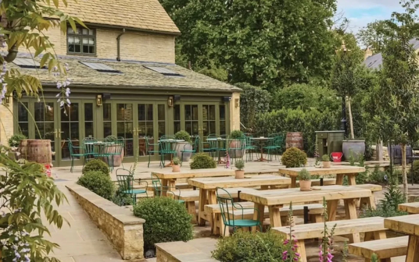 A formal garden terrace with clipped topiary and mixed borders